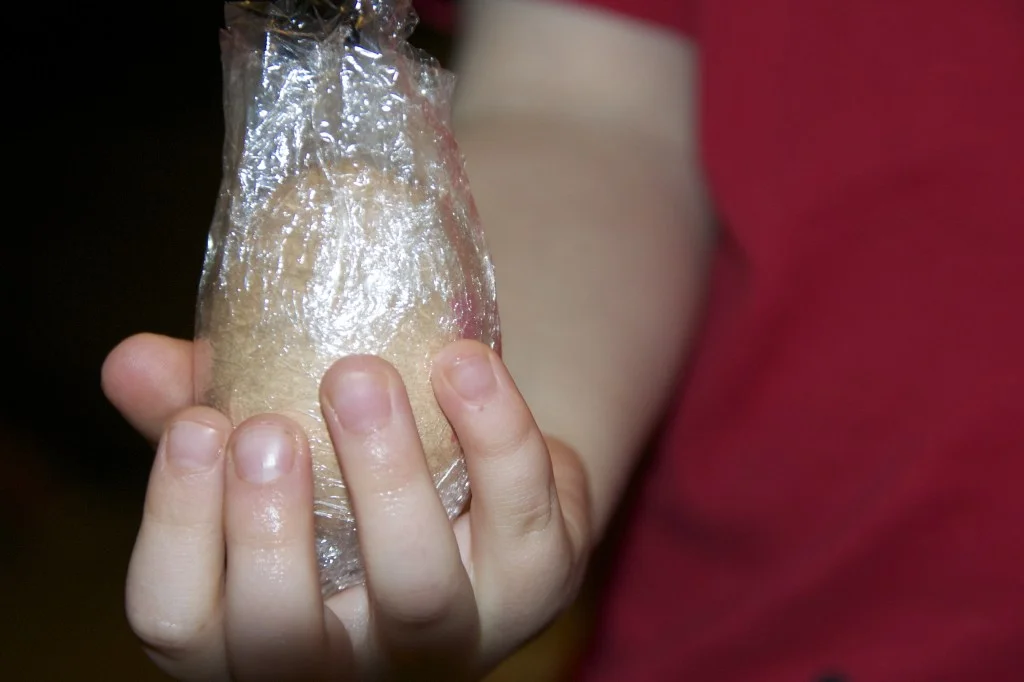 Child's hands squeezing an egg for a science demonstration