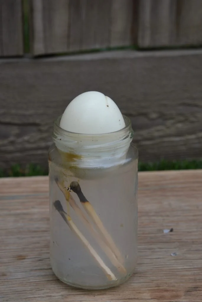 Egg being pulled into a bottle because of air pressure.